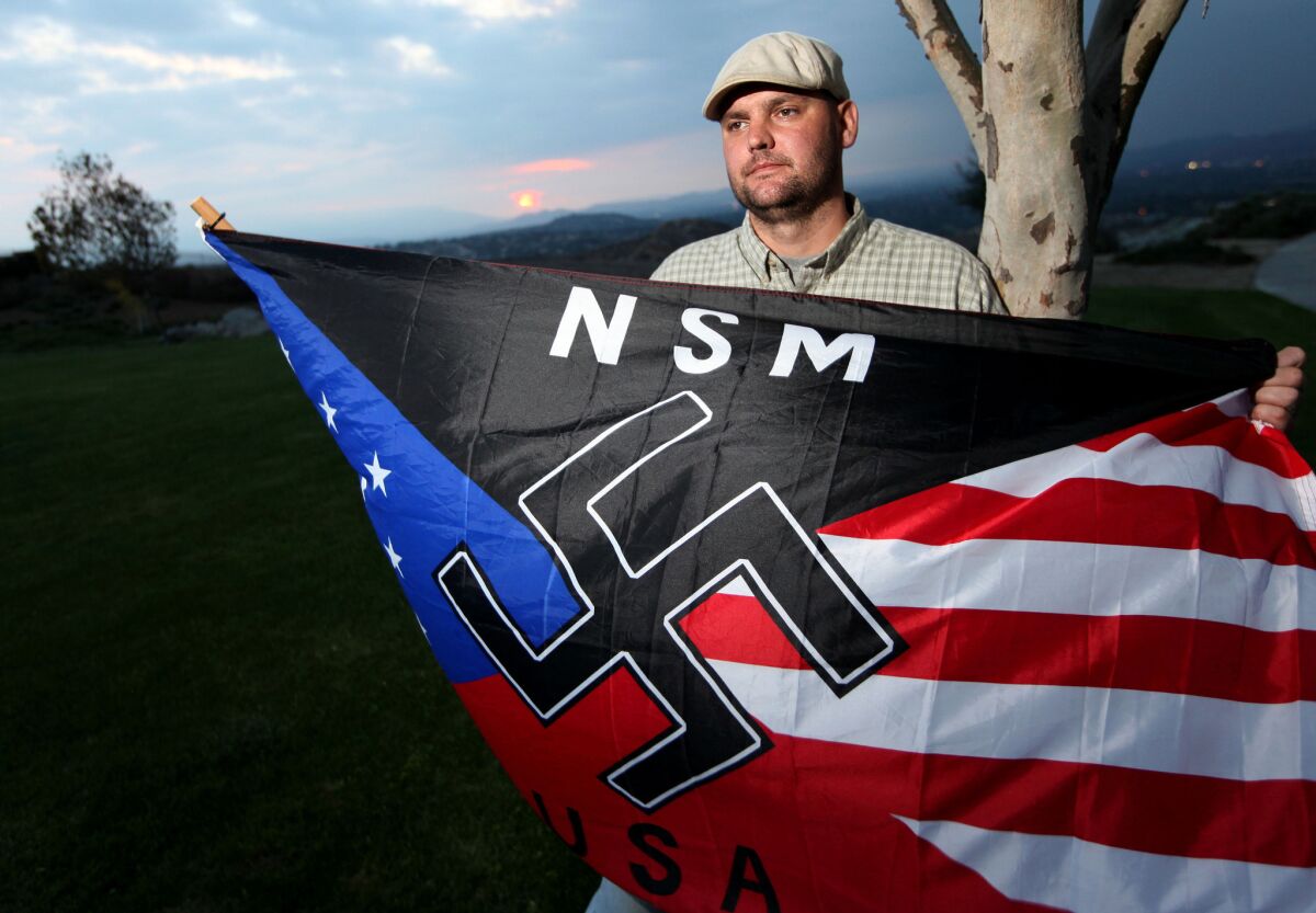 Jeff Hall holds a neo-Nazi flag while standing at Sycamore Highlands Park near his home in Riverside in 2010. His 10-year-old son was later convicted of killing Hall.