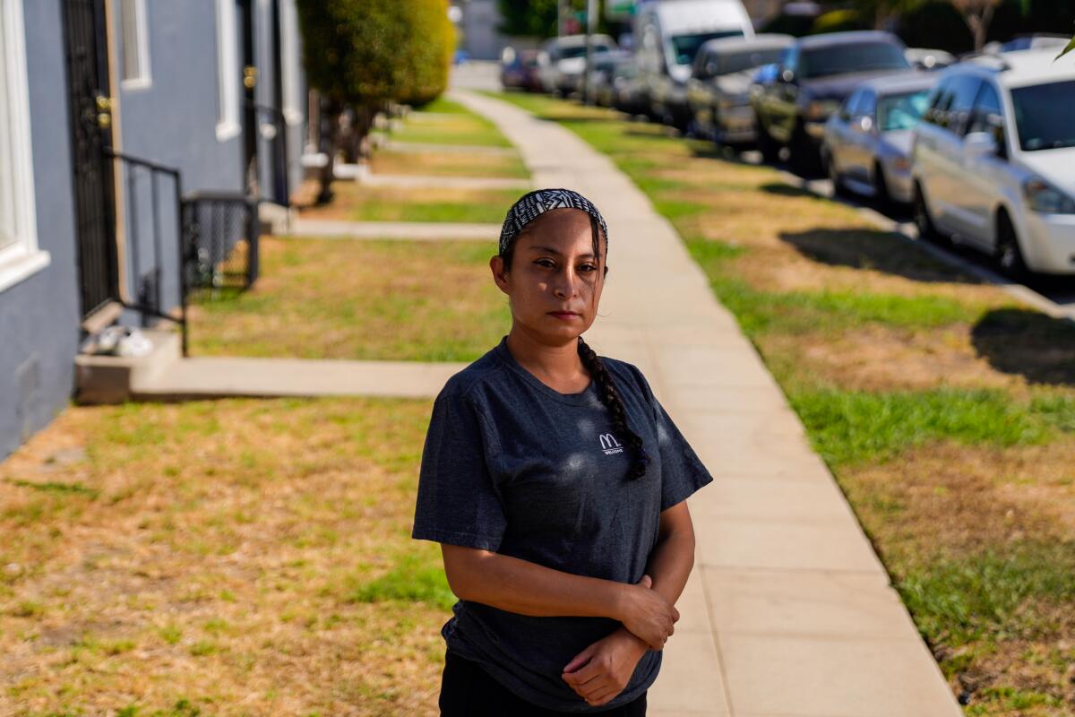 McDonald's worker Lizzet Aguilar poses for a portrait outside while wearing a T-shirt with the McDonald's logo
