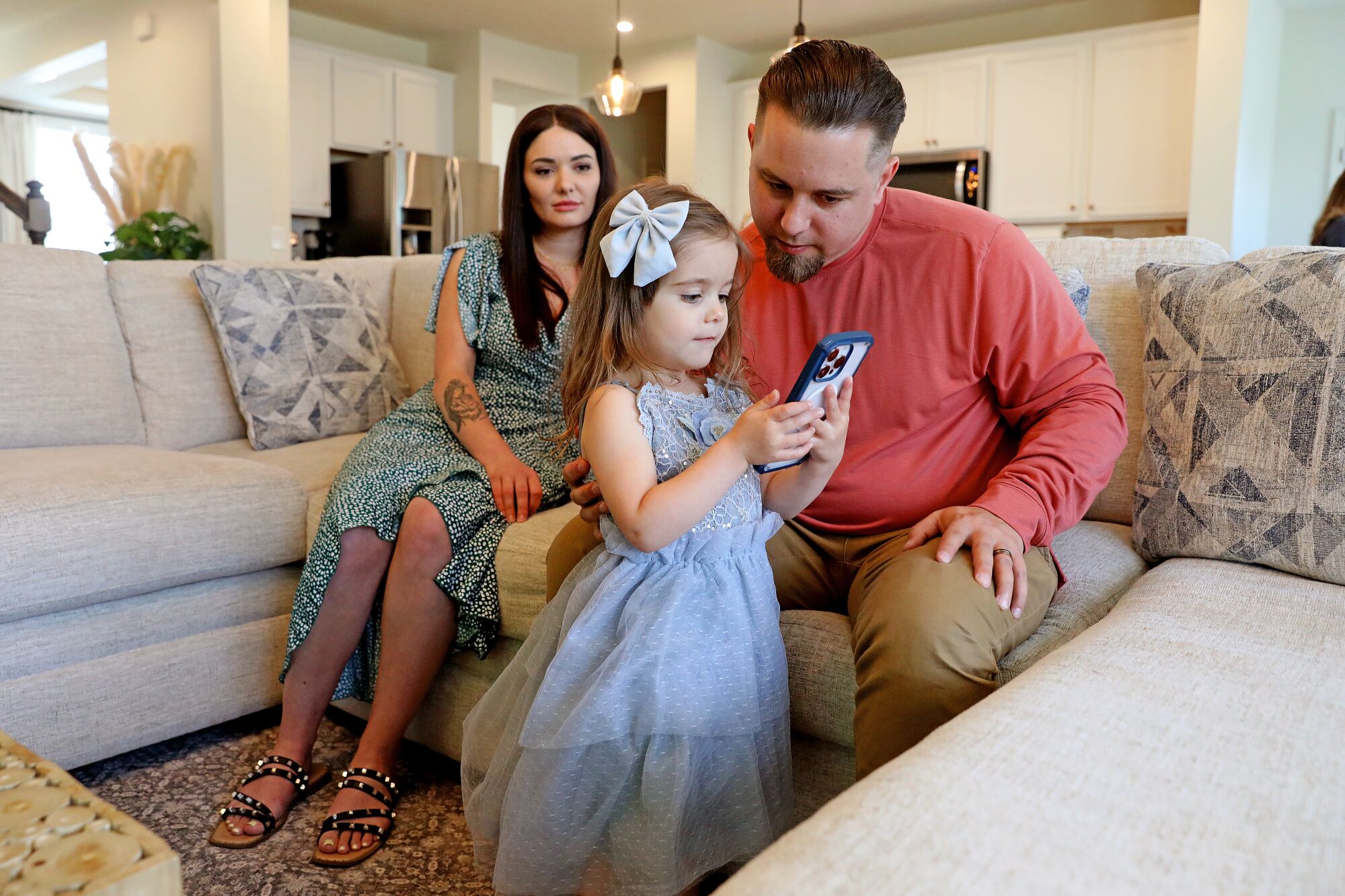 A couple and their young daughter in their living room