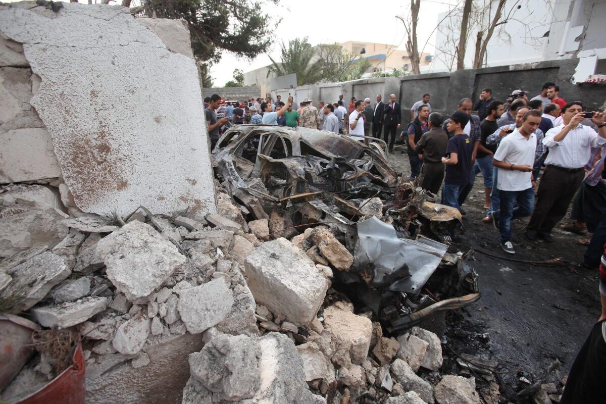 Libyan security forces gather outside the French Embassy in Tripoli following a car bomb blast.