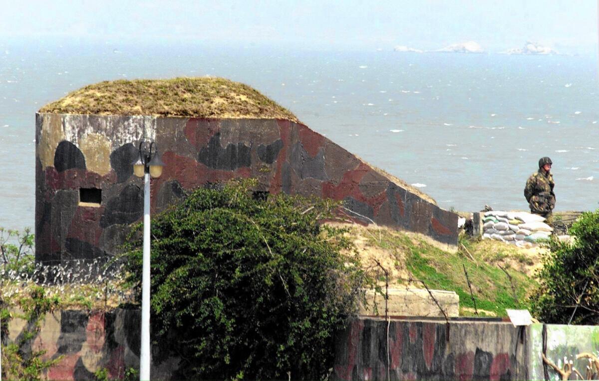 A Taiwanese soldier stands guard at a bunker on the fortified coastline of Taiwan's Kinmen island. Now much of this area is open to tourists.