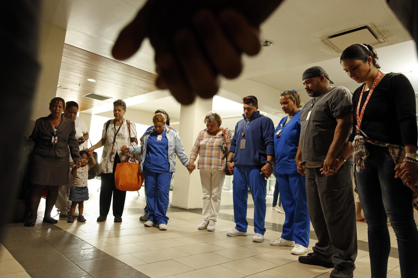 Hospital employees and nurses gather to pray for a co-worker who was critically injured in a violent attack during the chaos after Hurricane Maria hit Puerto Rico.