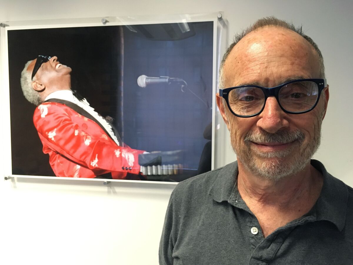 FILE - In this June 18, 2018, file photo, Gregory Katz, acting London bureau chief for The Associated Press, poses for a photo backdropped by a photo of American pianist singer songwriter Ray Charles, at the AP's London office. Katz, an acclaimed correspondent for The AP whose career over four decades took him across the globe, died Monday, June 22, 2020. He had been ill in recent months and had contracted COVID-19. He was 67. (AP Photo/File)