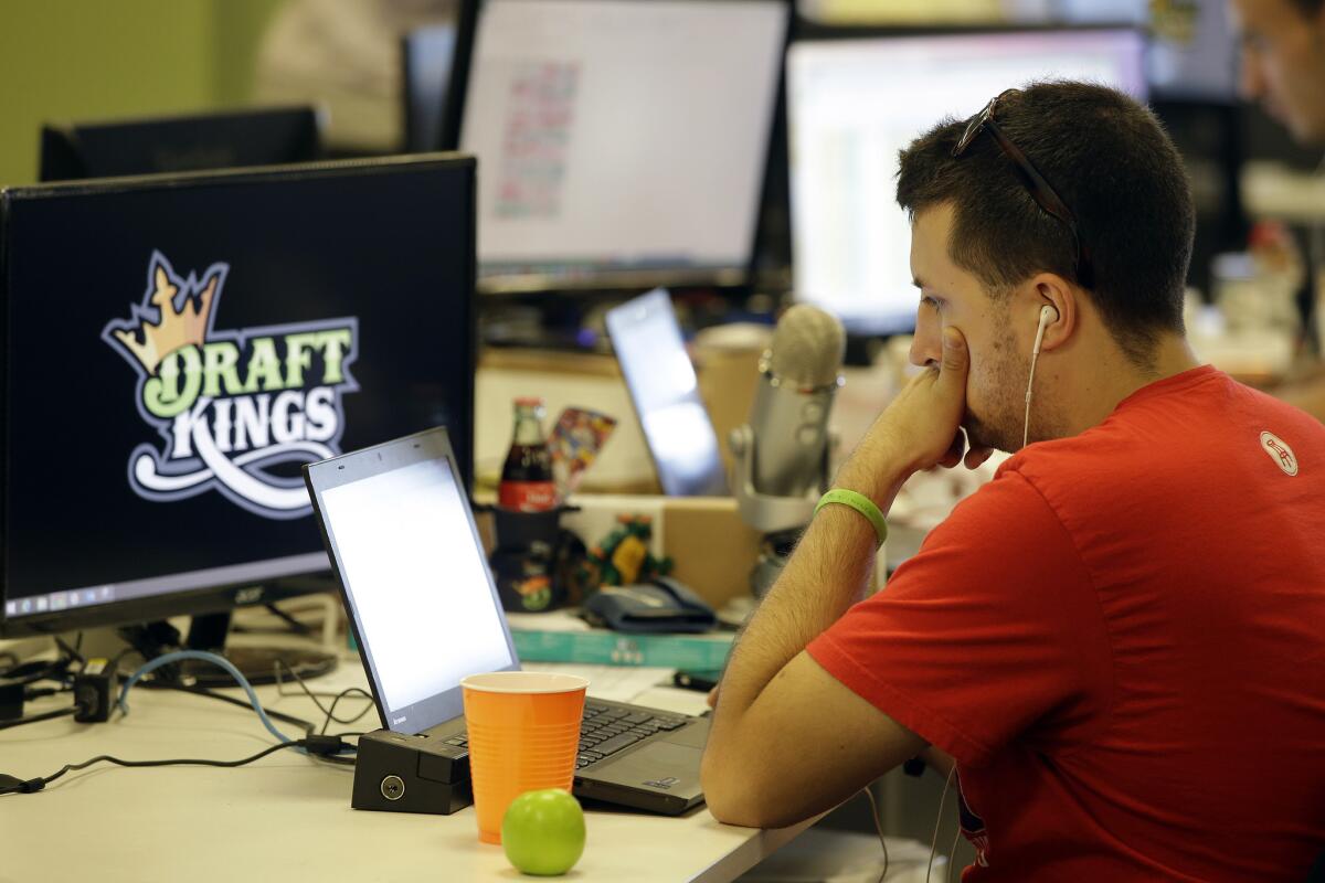 Devlin D'Zmura, a news manager at daily fantasy sports service DraftKings, works on his laptop at the company's offices in Boston in September.