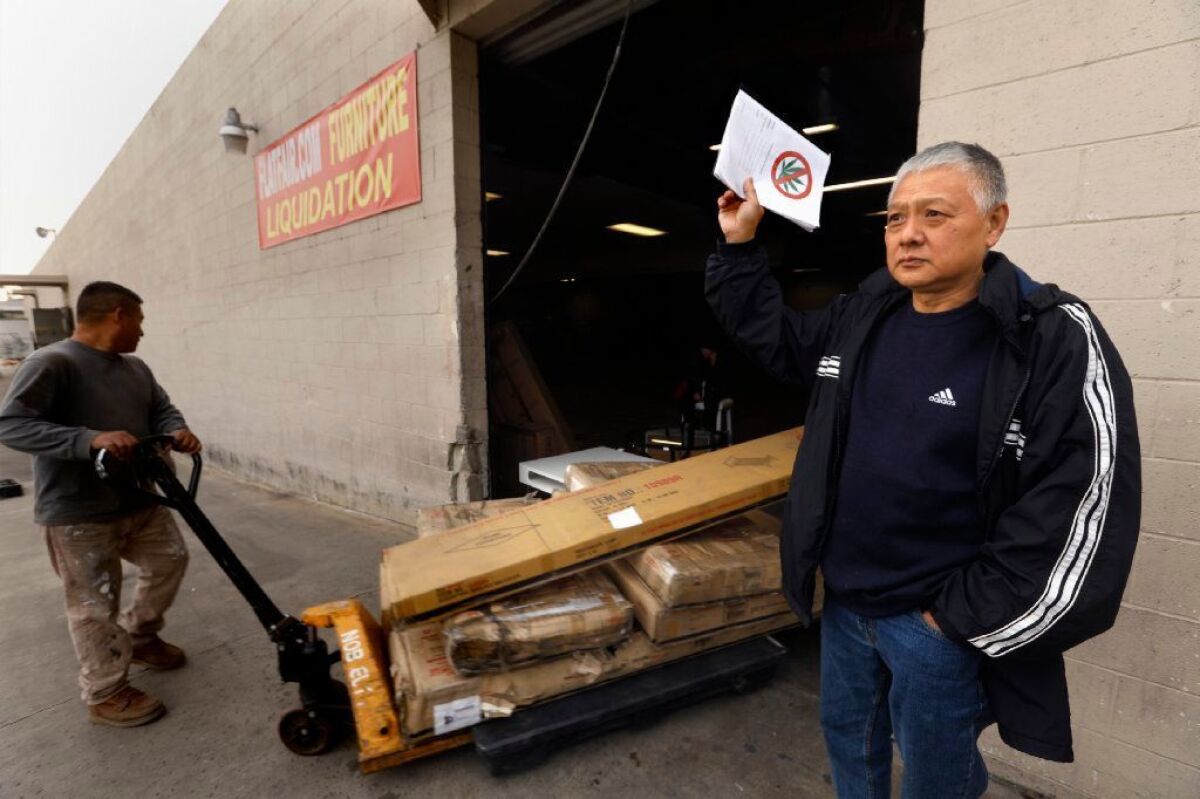 Cliff Chih, 58, an opponent of the marijuana production development, stands next to the warehouse that is slated to house the facility. Chih said a relative is addicted to the substance, and he worries about other young people.