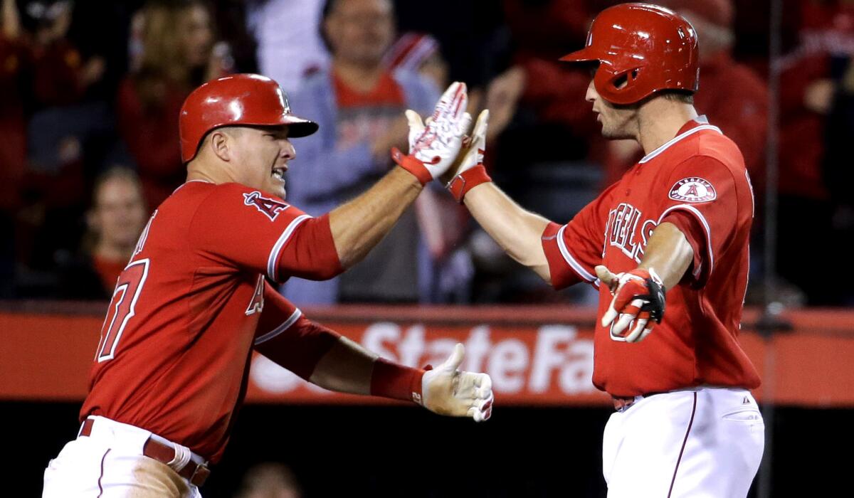 Angels third baseman David Freese, right, is congratulated by center fielder Mike Trout after hitting a two-run home run against the Rangers in the seventh inning Friday night.