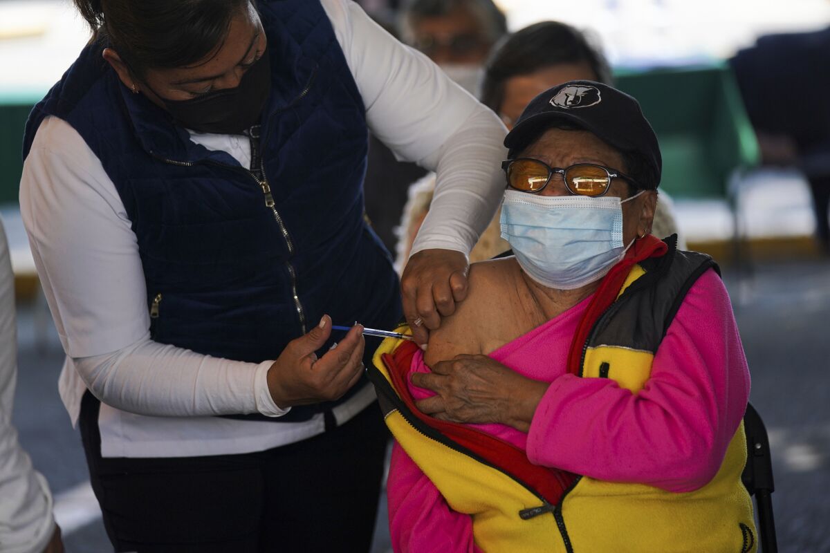 A woman receives a booster against COVID-19 during a vaccination campaign for people 60 and over