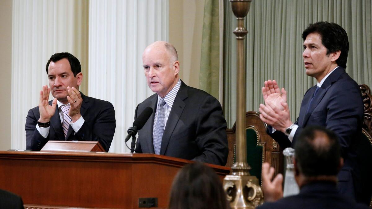 Gov. Jerry Brown, flanked by Assembly Speaker Anthony Rendon, left, and Senate President Pro Tem Kevin de León. Brown signed a bill that pares the state tax board from 4,800 workers to just 400 employees.