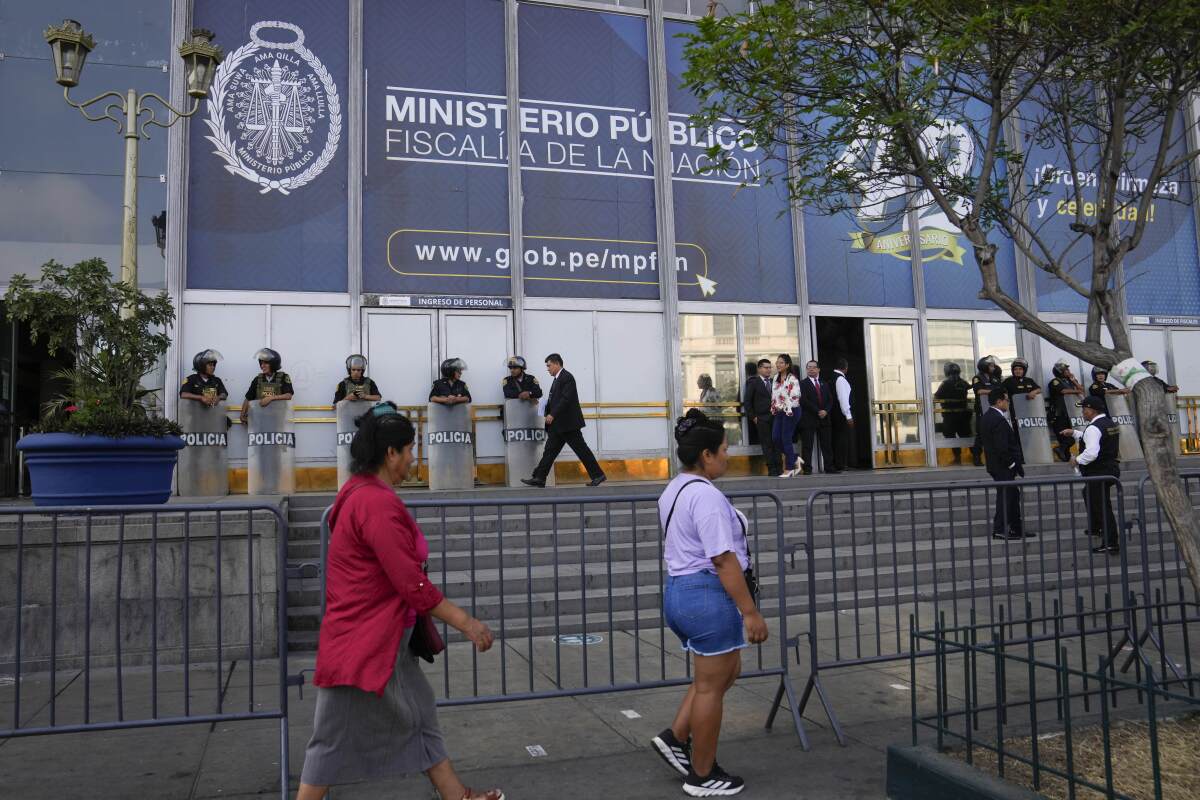 Los peatones pasan frente a la Fiscalía donde la presidenta peruana Dina Boluarte llegó a testificar en Lima, Perú