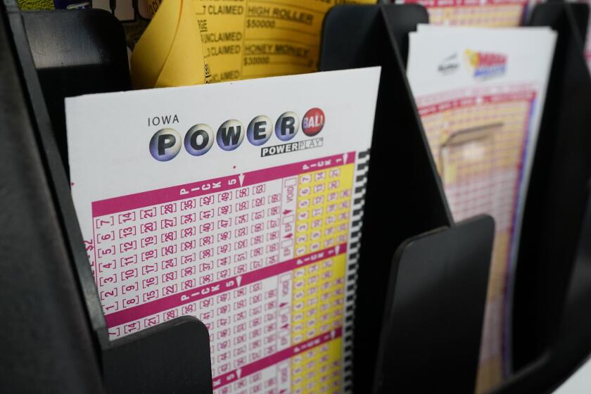 FILE - In this Jan. 12, 2021 file photo, blank forms for the Powerball lottery sit in a bin at a local grocery store, in Des Moines, Iowa. After nearly four months without a big winner, the Powerball jackpot has climbed to an estimated $620 million. That makes it the 10th largest U.S. lottery prize ahead of Saturday, Oct. 2, 2021, night's drawing. (AP Photo/Charlie Neibergall)