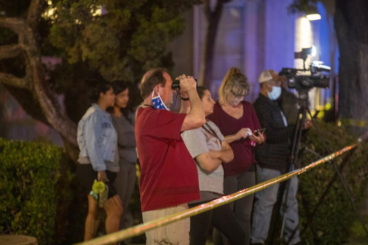 People stand outside a line of police tape