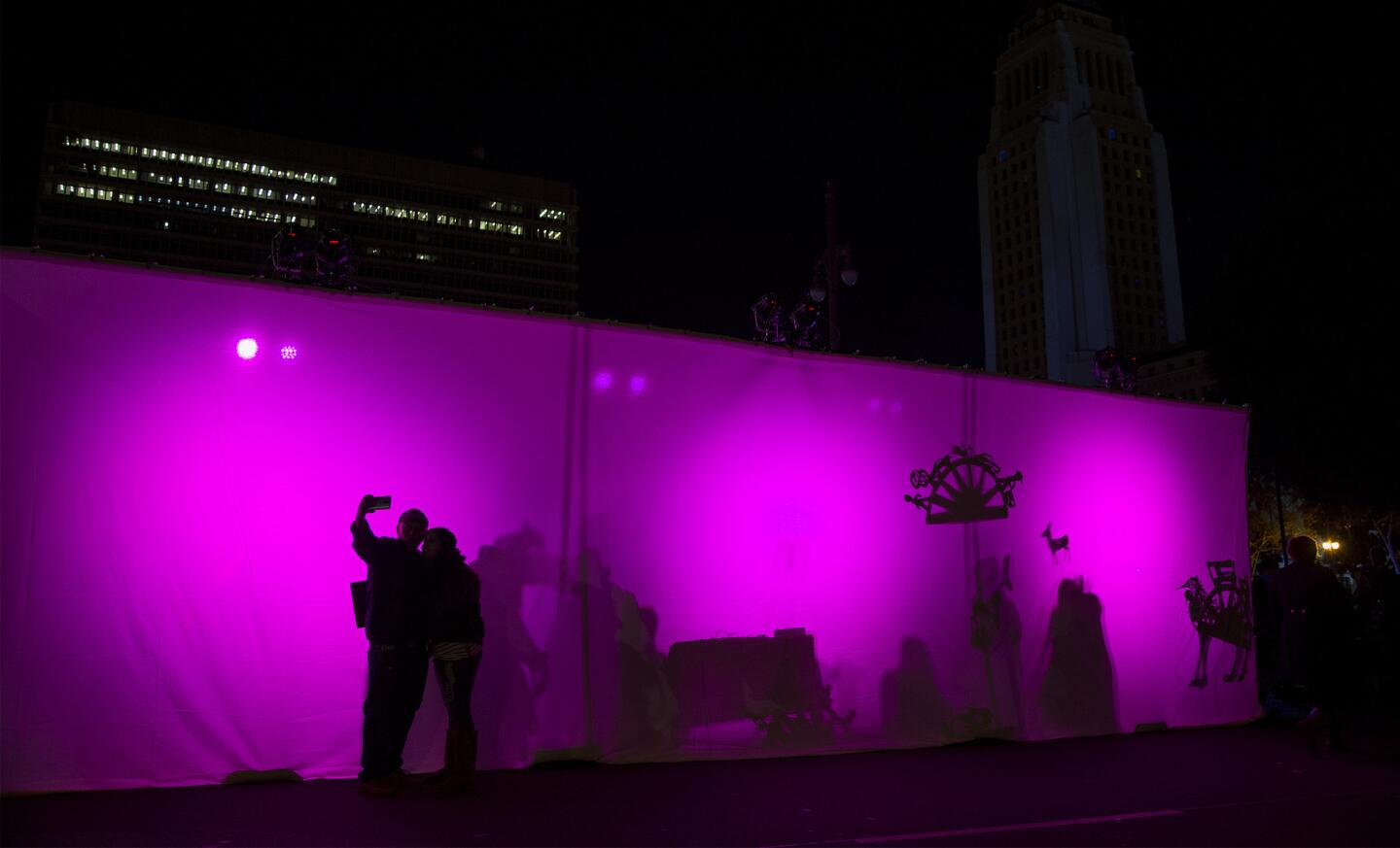 A couple pose for a selfie outside a puppet booth during the New Year's Eve celebration at Grand Park in Los Angeles.