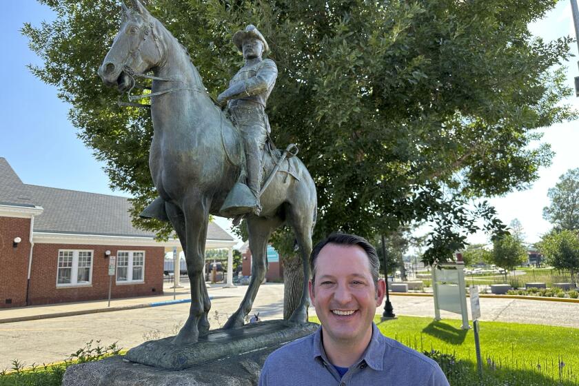 FILE - Theodore Roosevelt Presidential Library CEO Ed O'Keefe stands near a bronze statue of the 26th president, Aug. 23, 2023, in Mandan, N.D. Supporters of the Theodore Roosevelt Presidential Library are cheering new federal legislation to help build the library and to showcase artifacts of the 26th president, who as a young man hunted and ranched in the state during its territorial days. (AP Photo/Jack Dura, File)