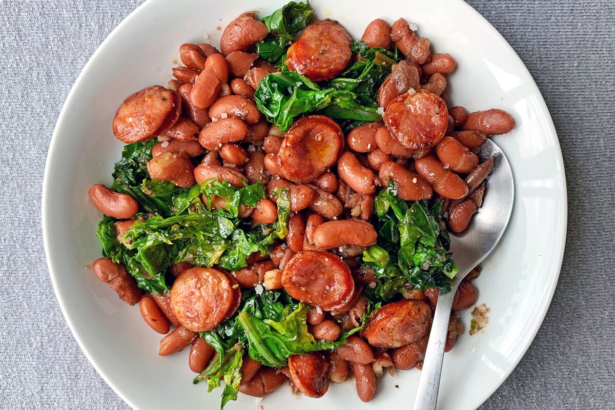 Spicy andouille sausage flavors both red kidney beans and sautéed young mustard greens in this comforting one-pot dish.