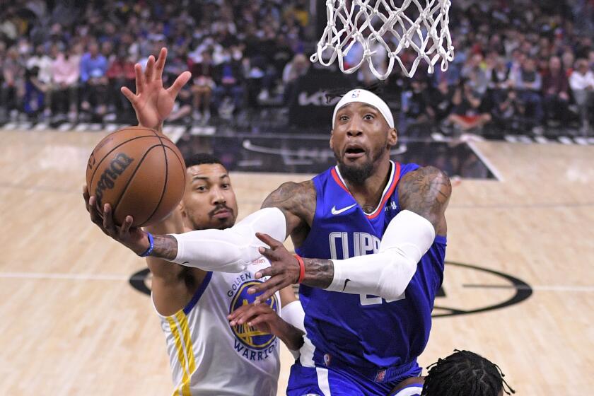 Los Angeles Clippers forward Robert Covington, right, shoots as Golden State Warriors.