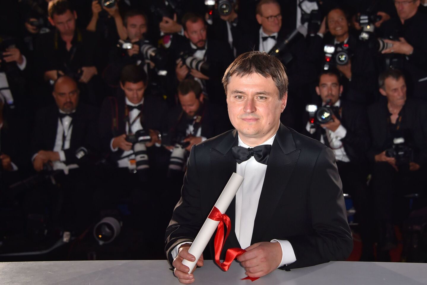 Romanian director Cristian Mungiu with his trophy during a photo call after he was awarded the Best Director prize for the film "Graduation" ("Bacalaureate").
