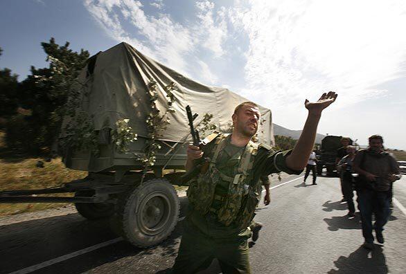 A Russian convoy moves toward Tbilisi, the capital of Georgia, alongside Georgians fleeing Gori. Eyewitnesses said Russians rounded up men, raped women and set fire to homes in ethnic Georgian villages in and around South Ossetia, a breakaway republic of Georgia.