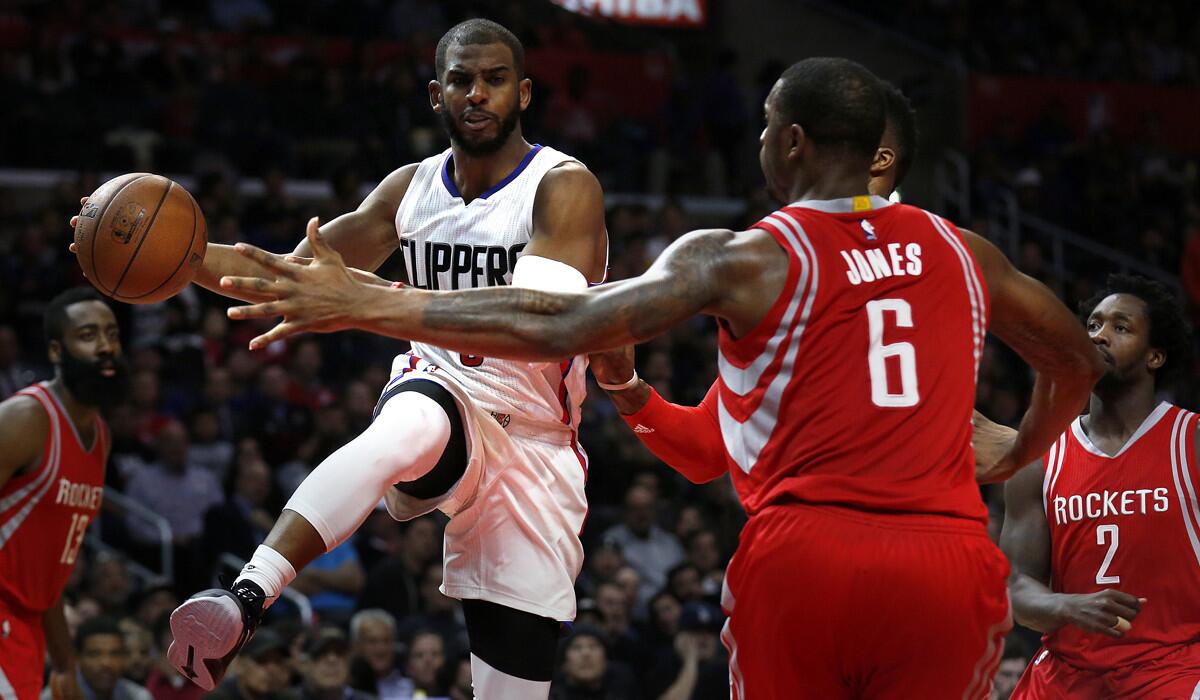 Los Angeles Clippers' Chris Paul, left, looks for a passing lane during the game against the Houston Rockets on Monday.