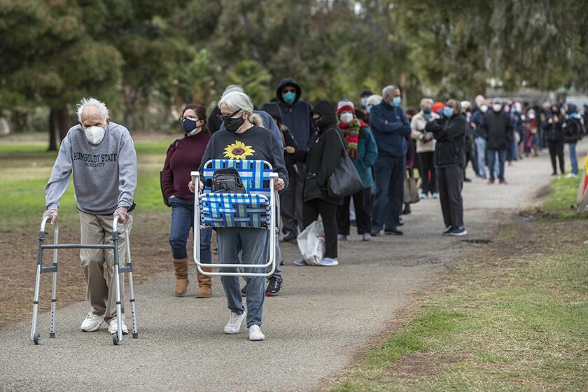 Residents line up to get COVID-19 vaccine shots at the Balboa Sports Complex in Encino on Wednesday.