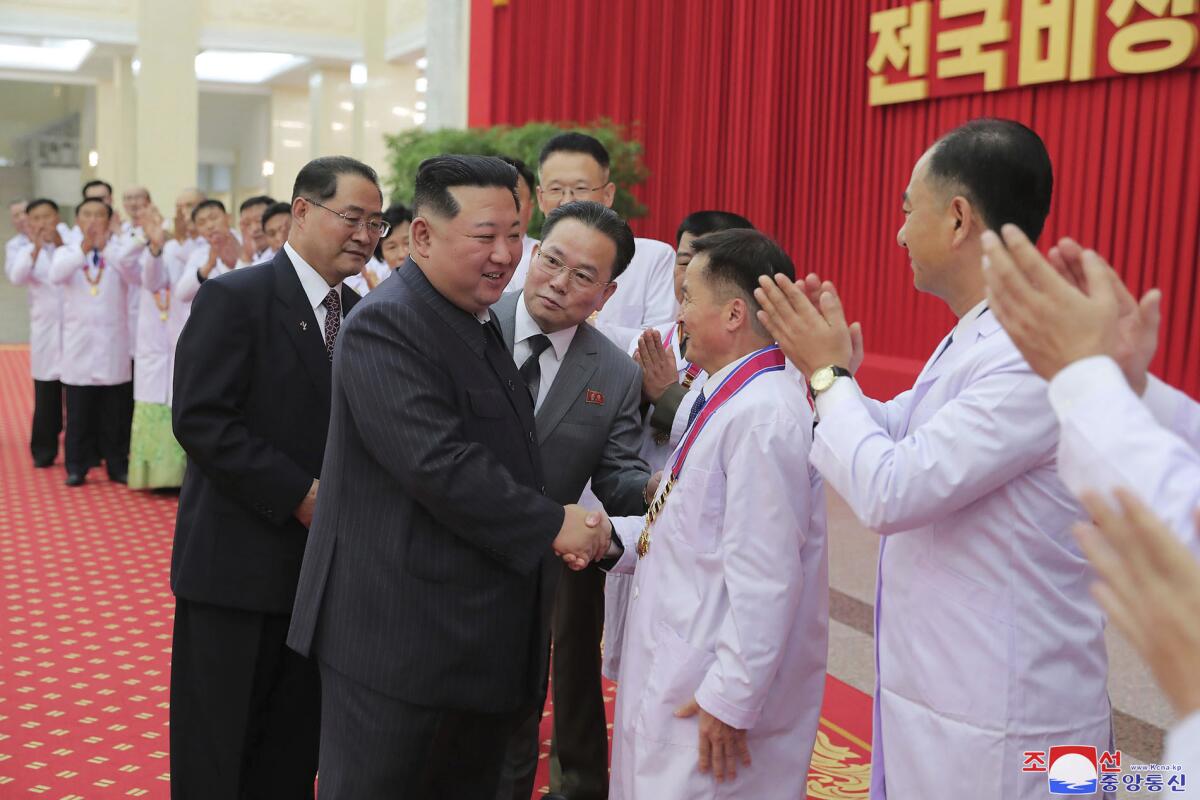 In this photo provided by the North Korean government, North Korean leader Kim Jong Un shakes hands with a health official in Pyongyang, North Korea, Wednesday, Aug. 10, 2022. Kim has declared victory over COVID-19 and ordered an easing of preventive measures. Independent journalists were not given access to cover the event depicted in this image distributed by the North Korean government. The content of this image is as provided and cannot be independently verified. Korean language watermark on image as provided by source reads: "KCNA" which is the abbreviation for Korean Central News Agency. (Korean Central News Agency/Korea News Service via AP)