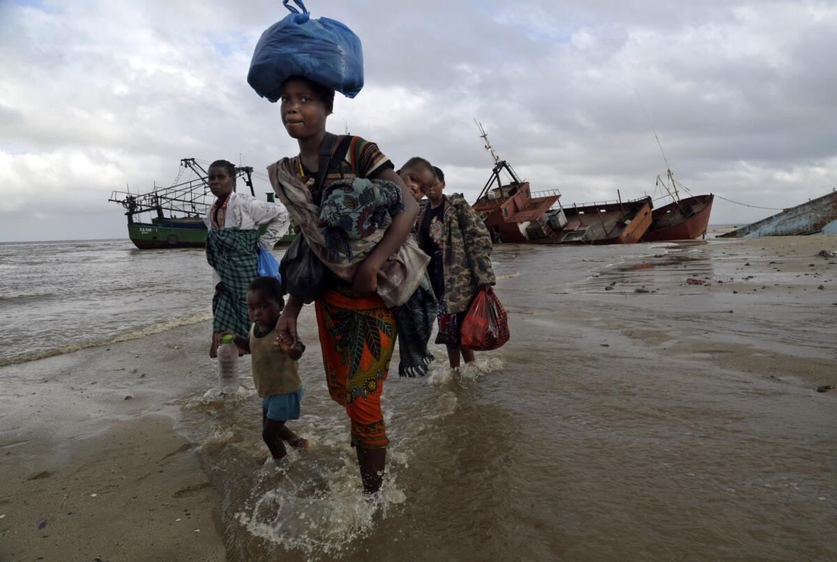 Displaced family wading through water