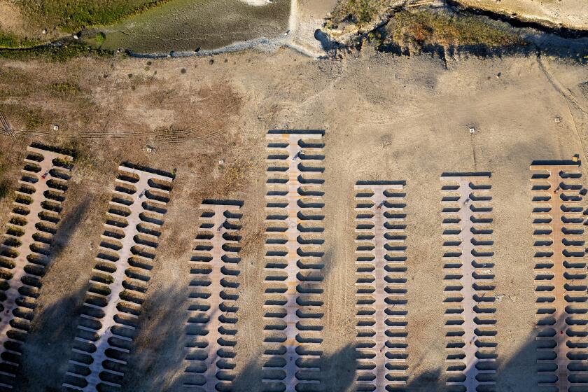 FOLSOM, CA - JULY 01: Boat slips lay stranded on dry land as water levels recede at drought-stricken Folsom Lake, which stands XX% full, but the average for the date is XX% of average, reflecting the ongoing drought when this photograph was taken on Thursday, July 1, 2021 in Folsom, CA. (Brian van der Brug / Los Angeles Times)