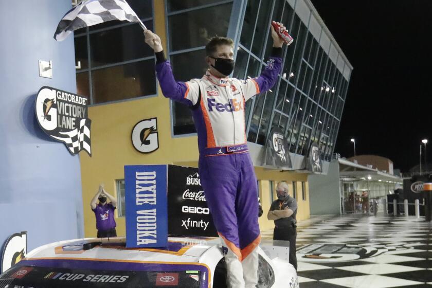 Denny Hamlin celebrates after winning a NASCAR Cup Series auto race.