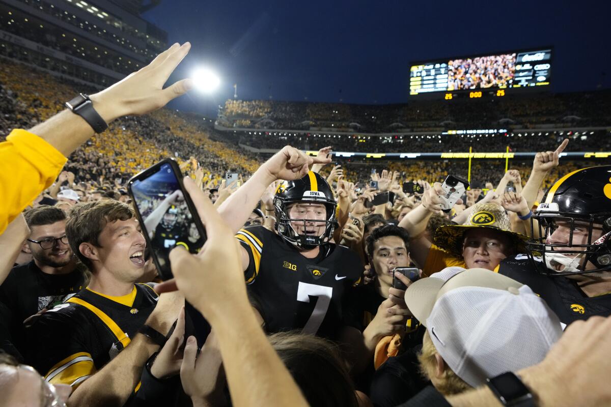 Iowa quarterback Spencer Petras (7) celebrates with fans on the field after Iowa beat Penn State 23-20, in an NCAA college football game, Saturday, Oct. 9, 2021, in Iowa City, Iowa. (AP Photo/Matthew Putney)