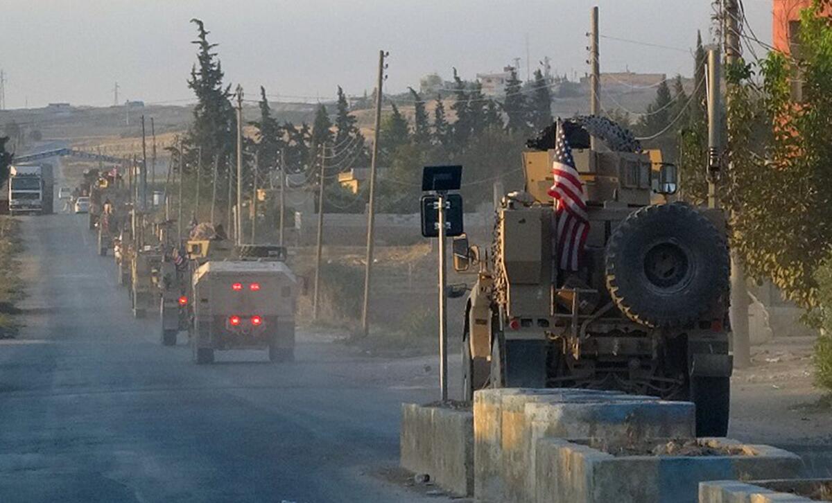 U.S. military vehicles travel a main road in northeastern Syria on Oct. 7, 2019, the day after President Trump announced a U.S. troop withdrawal in the area.  