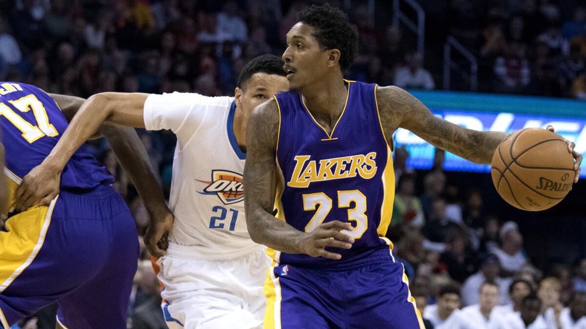 Lakers guard Lou Williams uses a screen to try to drive past Thunder guard Andre Roberson in the first half Saturday.