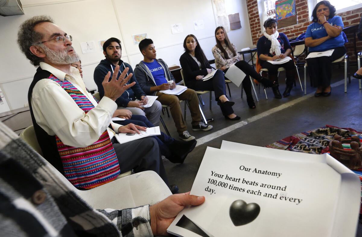 A man speaks in front of a circle of people