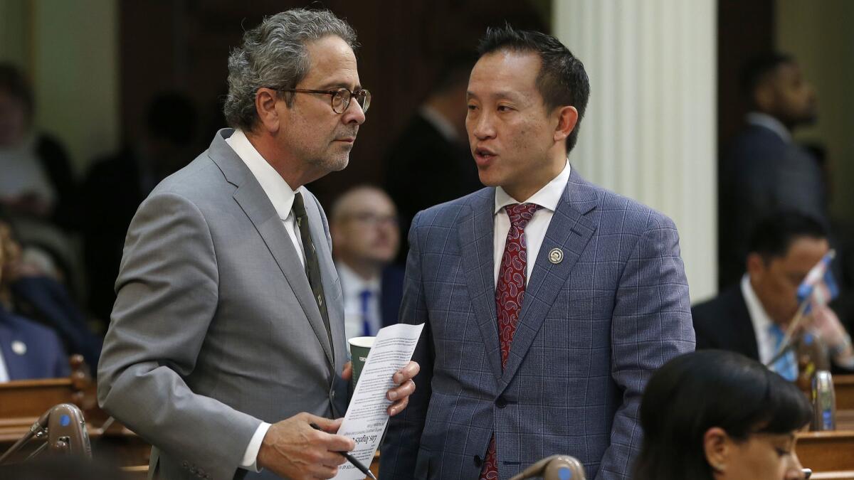 Democratic Assemblymen Richard Bloom of Santa Monica, left, and David Chiu of San Francisco talk during the Assembly session on May 29 in Sacramento. The Assembly approved Chiu's bill to cap rent increases, but only after major concessions to opponents.