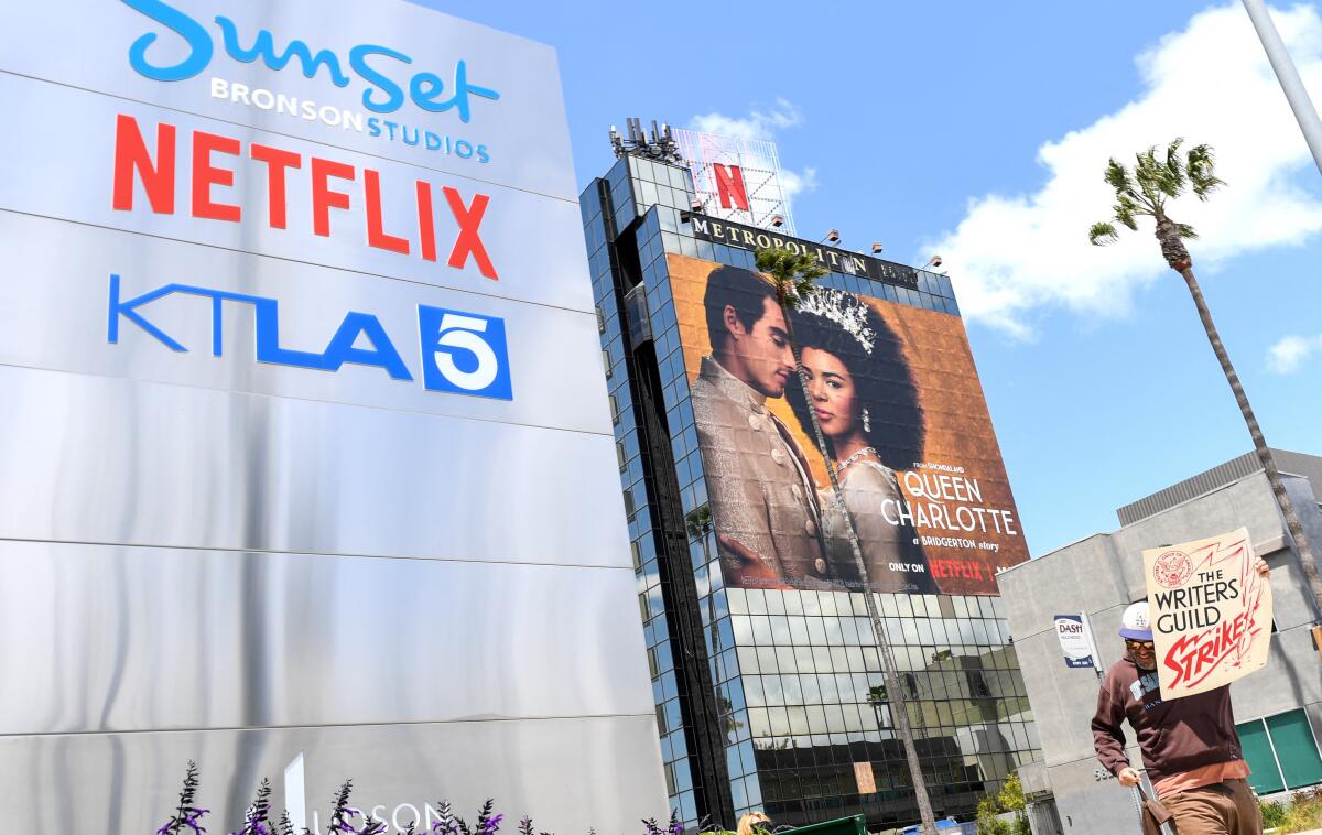 An ad for a Netflix show near the streaming service's office is shown while a person participates in a strike. 