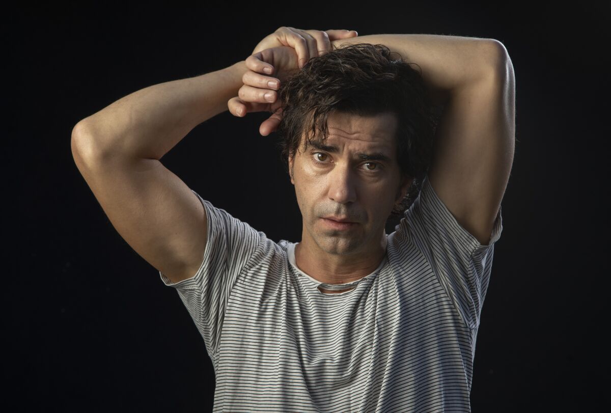 Hamish Linklater, the star of Netflix's new horror series "Midnight Mass," poses in a striped shirt