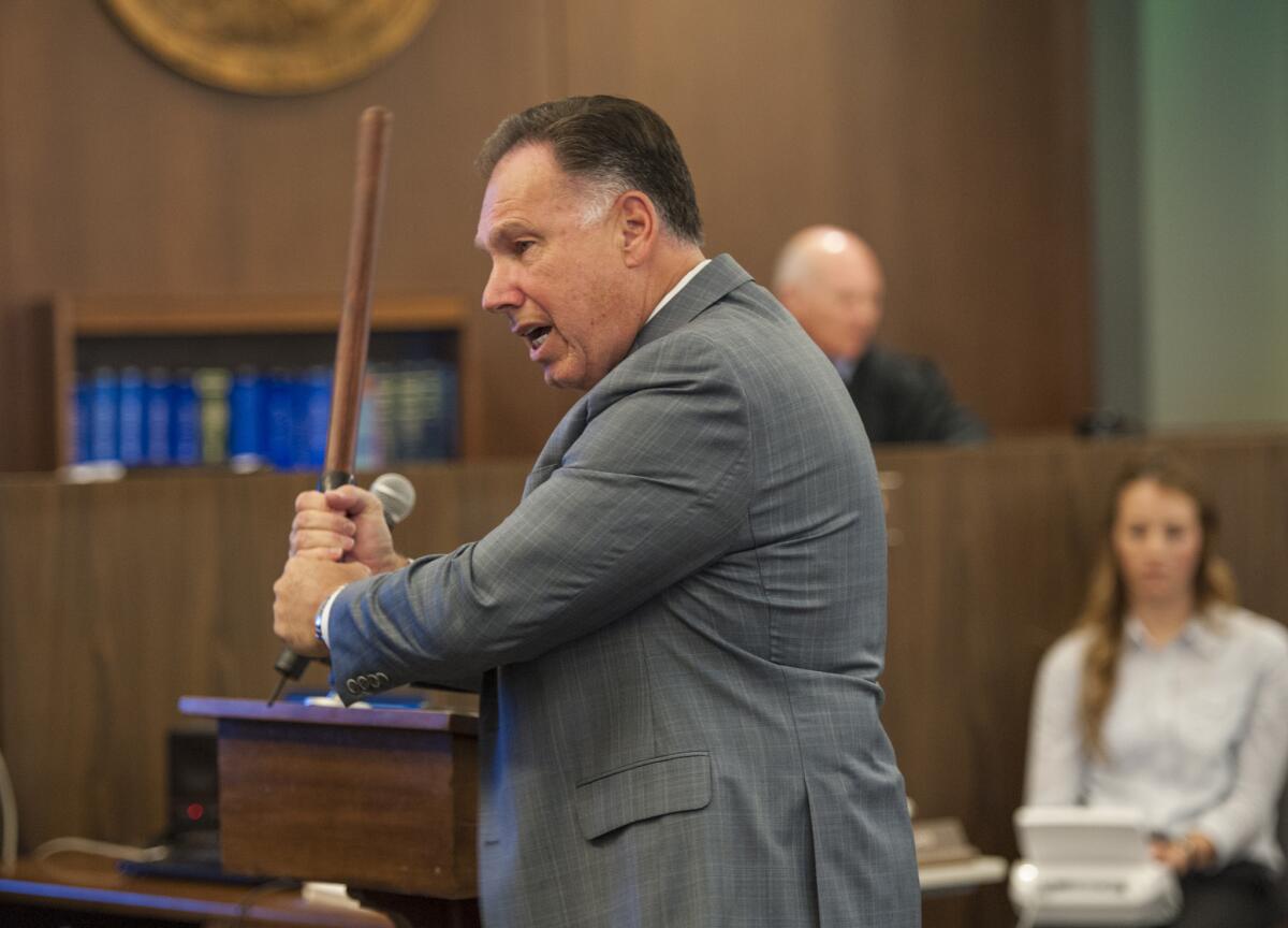 Orange County District Attorney Tony Rackauckas wields a police baton to demonstrate how he believes Fullerton police officers beat Kelly Thomas to death in 2011.
