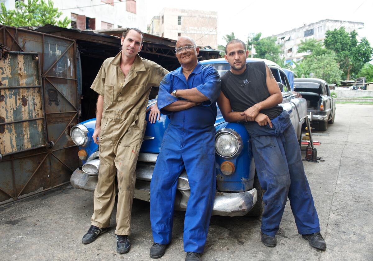 En esta imagen sin fecha difundida por Discovery en Español, Demetrio Montalvo, en el centro, con sus hijos Michel, a la izquierda, y Hernán, de "Cuban Chrome", una docu-serie sobre autos clásicos estadounidenses en Cuba. La serie se estrena el lunes 13 de julio del 2015.