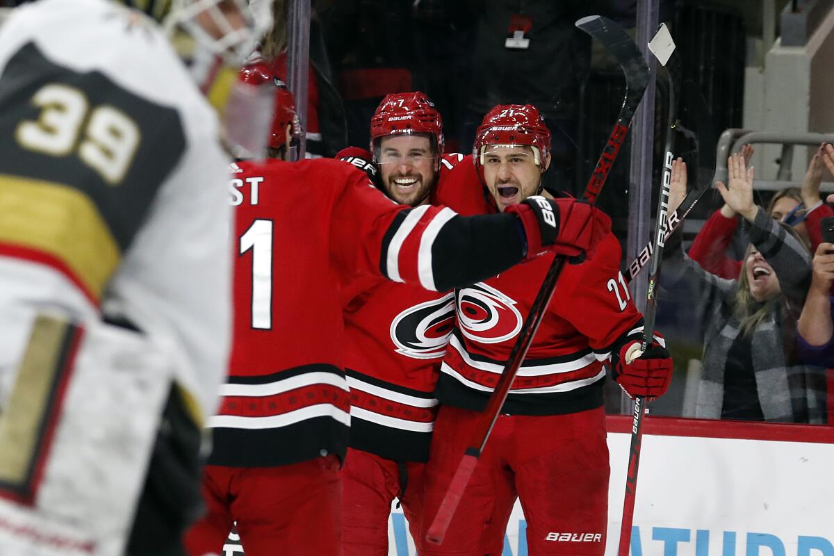 Carolina Hurricanes' Nino Niederreiter (21) celebrates his goal with teammate Brendan Smith (7) during the second period of an NHL hockey game against the Vegas Golden Knights in Raleigh, N.C., Tuesday, Jan. 25, 2022. (AP Photo/Karl B DeBlaker)