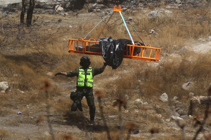 Forensic experts work with several bags of human remains extracted from the bottom of a ravine by a helicopter, which were abandoned at the Mirador Escondido community in Zapopan, Jalisco state, Mexico on May 31, 2023. The Jalisco Prosecutor's Office is investigating to find out if the remains belong to the 7 call center workers who disappeared on their way to work in recent days. (Photo by ULISES RUIZ / AFP) (Photo by ULISES RUIZ/AFP via Getty Images)