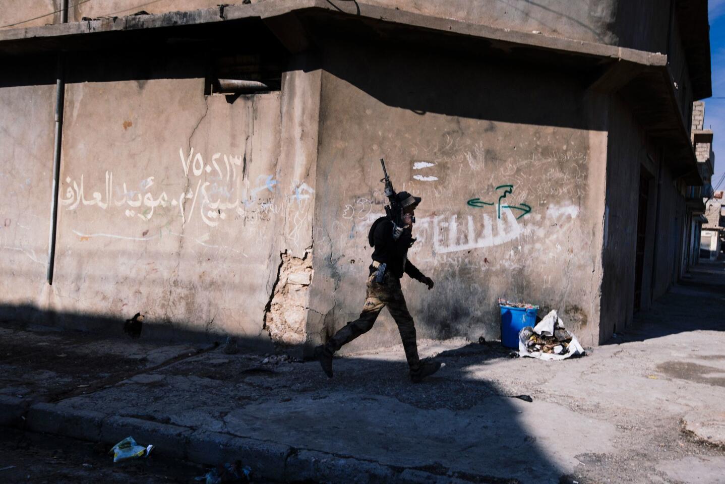 A member of the Iraqi special forces Counter Terrorism Service patrols in Mosul's al-Jazair neighbourhood as they look for Islamic State fighters on Jan. 17, 2017.