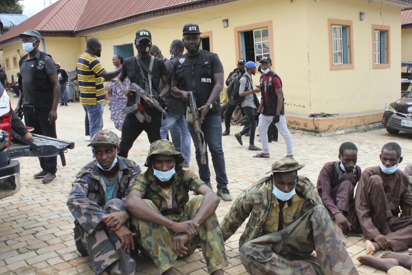 FILE - Three men seated on the ground, identified by police officers as kidnappers of The Bethel Baptist High School students, are shown to the media in Abuja, Nigeria. Thursday, Sept. 23, 2021. Nigerian lawmakers have taken steps to bar the payment of ransoms to kidnappers at a time when thousands are in captivity, including passengers kidnapped during a train attack in late March near the nation's capital. Nigeria's Senate has passed a bill amending the country's Terrorism Prevention Act to bar the ransom payments. On Thursday, April 28, 2022 it said the amendment will "prevent terrorist groups from laundering money. (AP Photo/Gbemiga Olamikan, File)