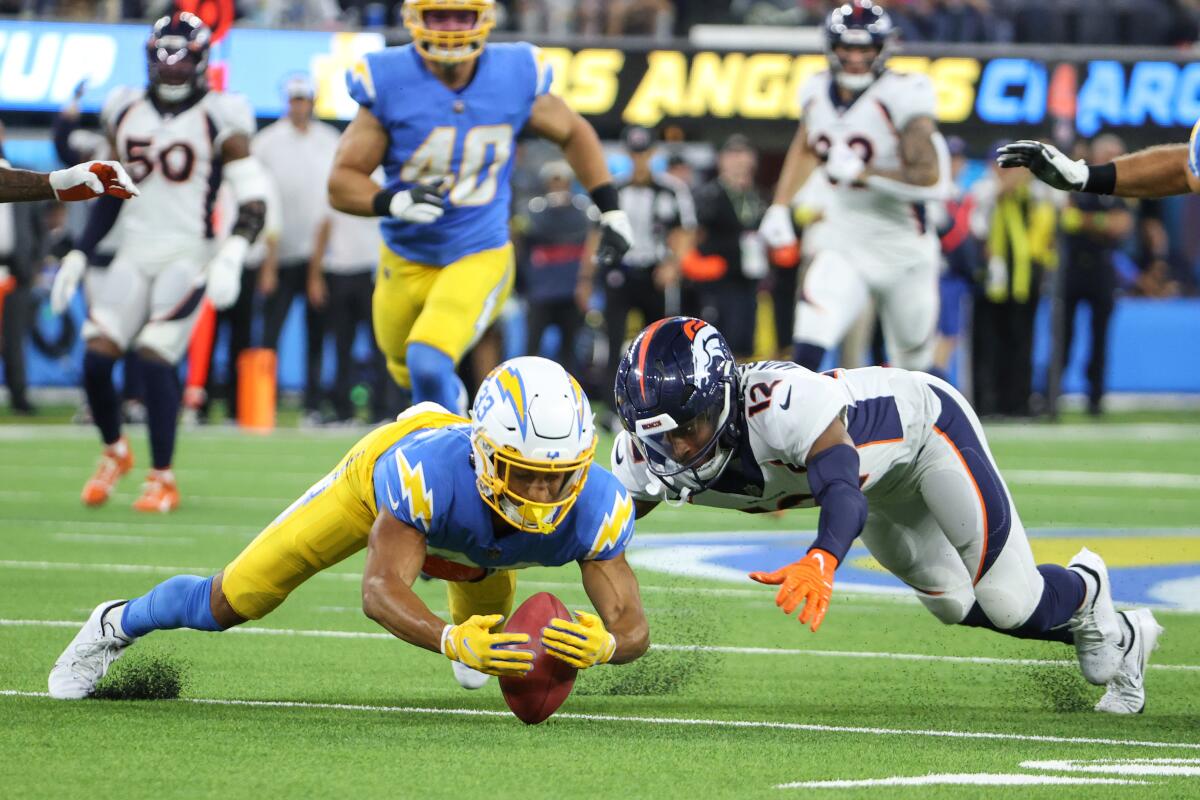 The Chargers' Deane Leonard recovers a punt muffed by the Broncos' Montrell Washington (12) in overtime.