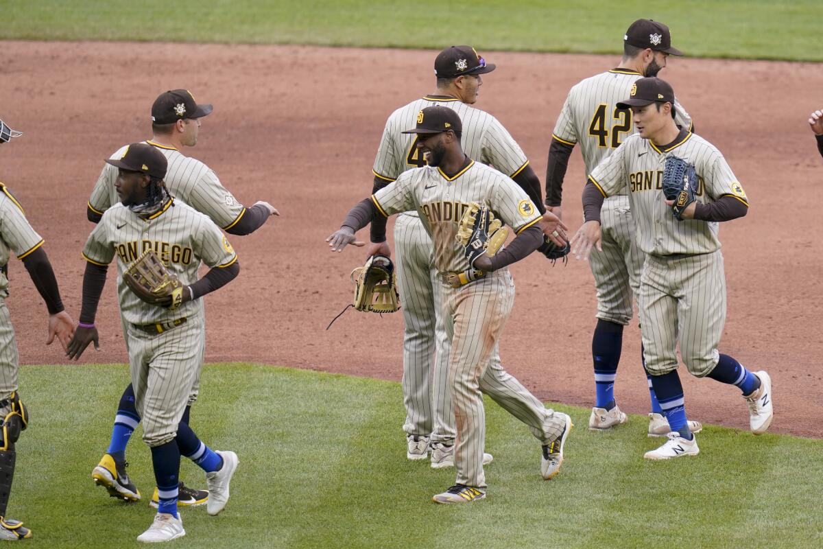 The San Diego Padres greet each other as they leave the field after defeating the Pittsburgh Pirates in a baseball game, Thursday, April 15, 2021, in Pittsburgh. The Padres won 8-3. (AP Photo/Keith Srakocic)