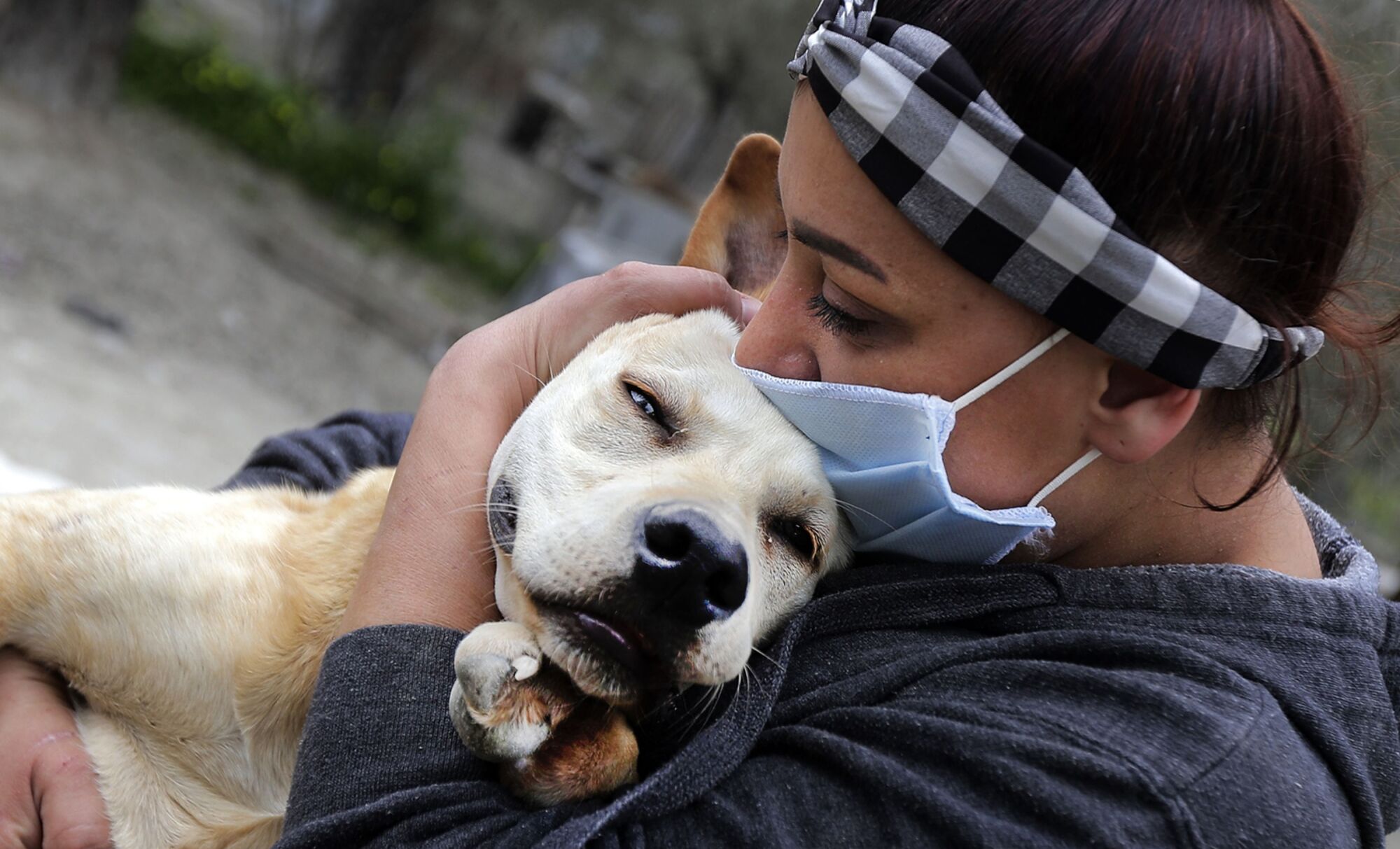 LEBANON: Zaynab Razzouk, head of the animal protection NGO Carma, hugs a dog at the shelter in the area of Koura, north of the Lebanese capital Beirut on April 3, 2020. - According to Razzouk, dogs and cats are getting dumped every day as a result of the outbreak of Covid-19.
