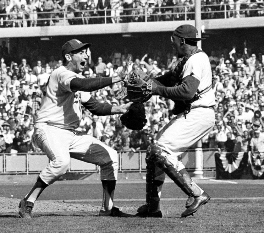 Dodgers pitcher Sandy Koufax (left) and catcher John Roseborough celebrate their victory over the New York Yankees.