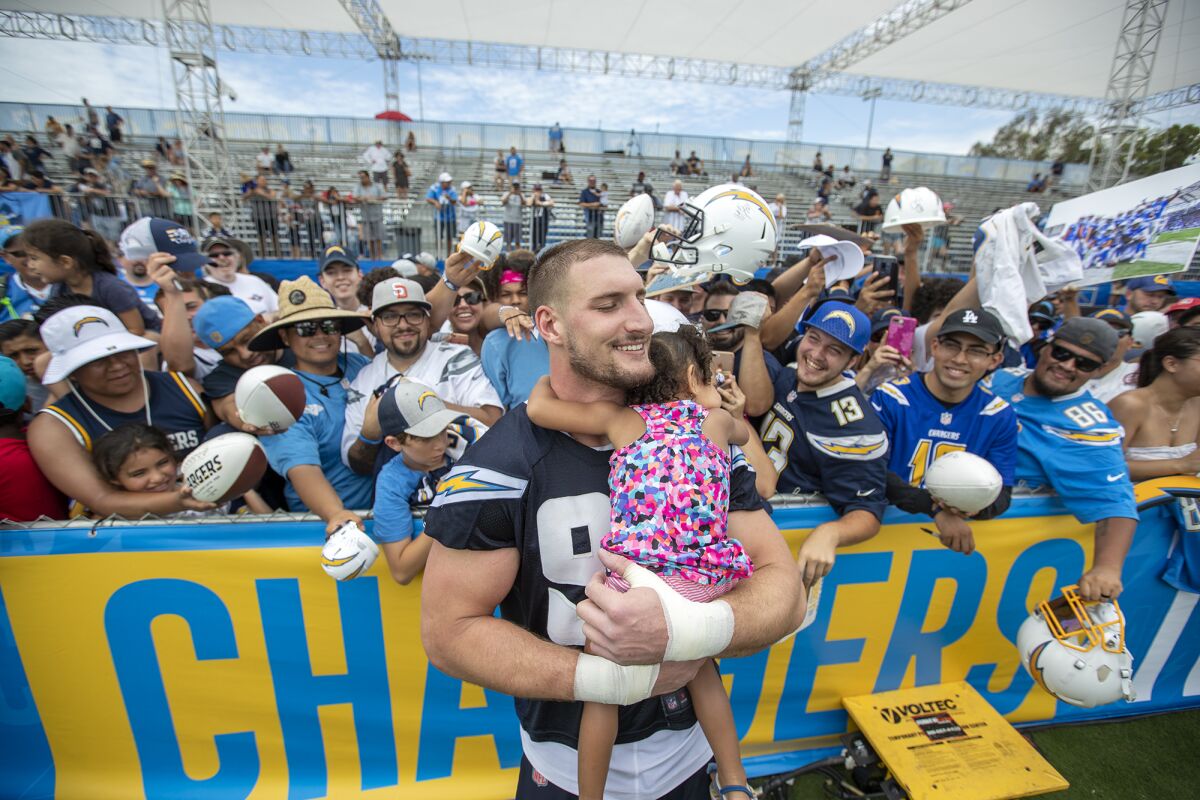 Chargers defensive end Joey Bosa hugs Nevaeh Williams, 2, on the first day of training camp on Thursday at Jack R. Hammett Sports Complex in Costa Mesa.