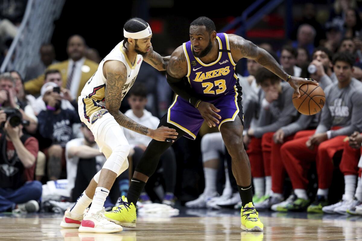 Lakers star LeBron James dribbles next to New Orleans Pelicans forward Brandon Ingram during the Lakers' win Sunday.
