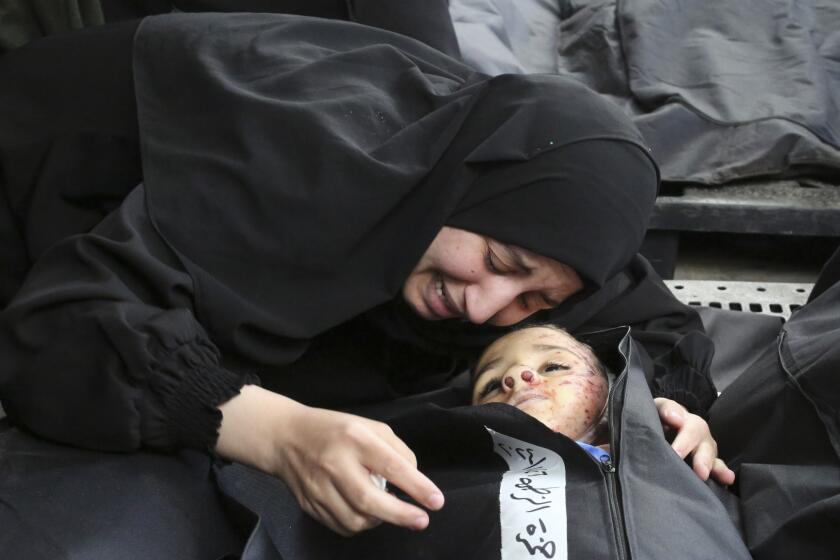A Palestinian woman mourns a child killed in the Israeli bombardment of the Gaza Strip at a morgue in Khan Younis, Tuesday, Feb. 27, 2024. (AP Photo/Hatem Ali)