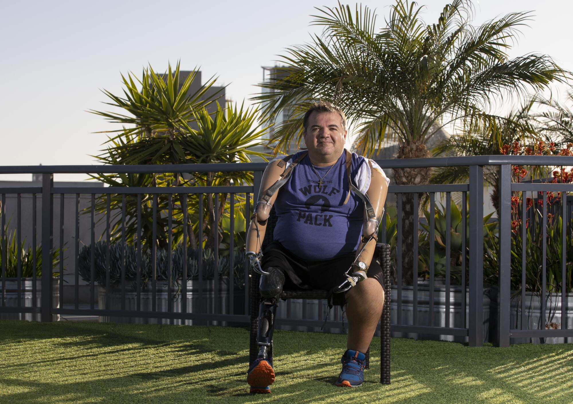A man with prosthetics sits on a chair on a rooftop garden