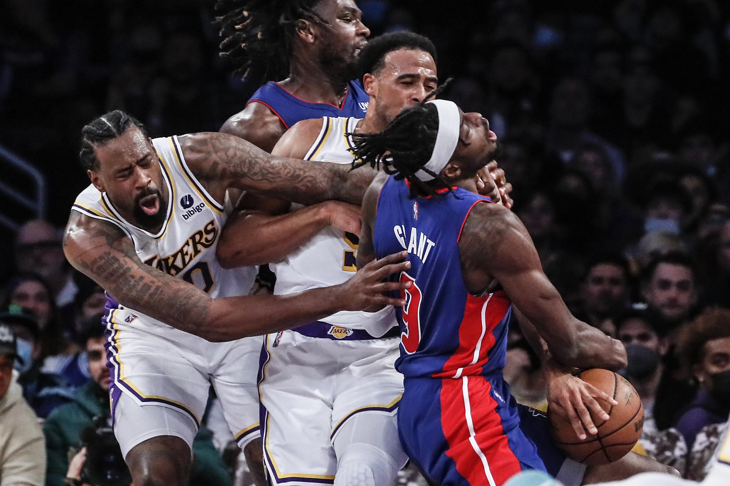 Pistons forward Jerami Grant is fouled by Lakers guard Talen Horton-Tucker and center DeAndre Jordan.