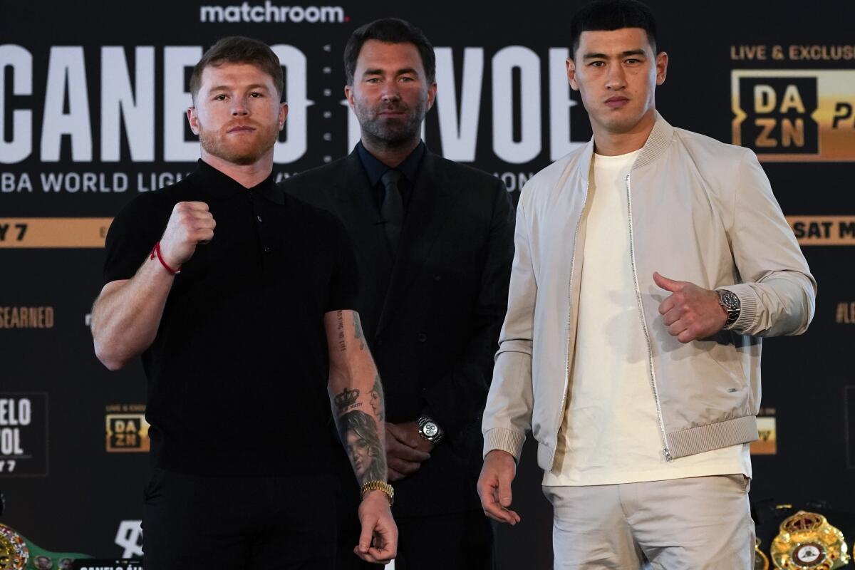 Canelo  Álvarez poses with boxer Dmitry Bivol during a weigh-in in advance of their boxing match.